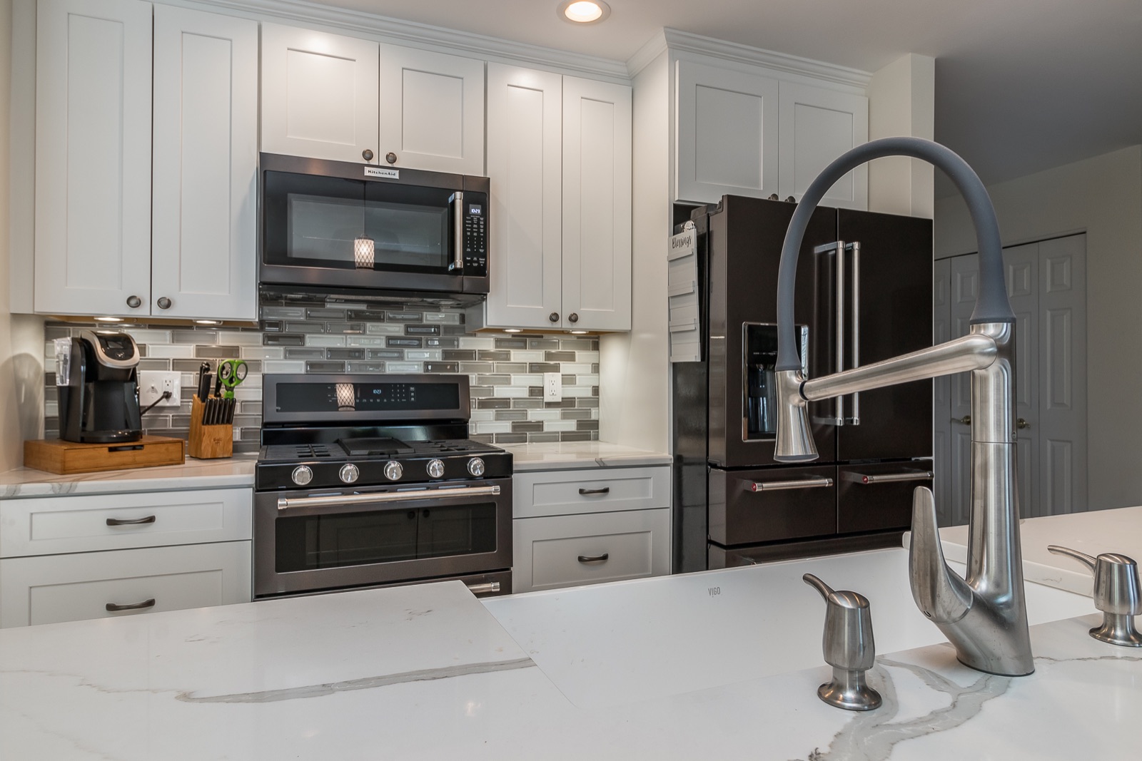 Completed Aurora kitchen renovation — Range wall and sculptural faucet